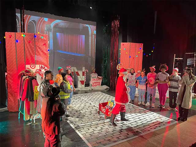 learners on stage circling Santa character 